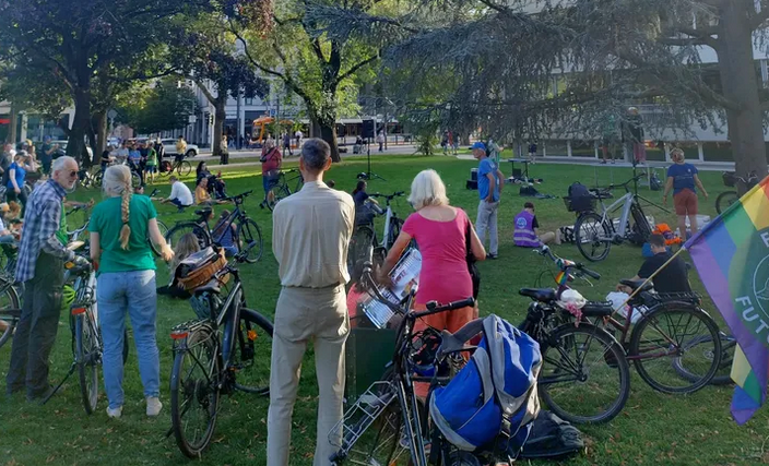 Junge Menschen treffen sich mit Fahrrädern auf einer Wiese